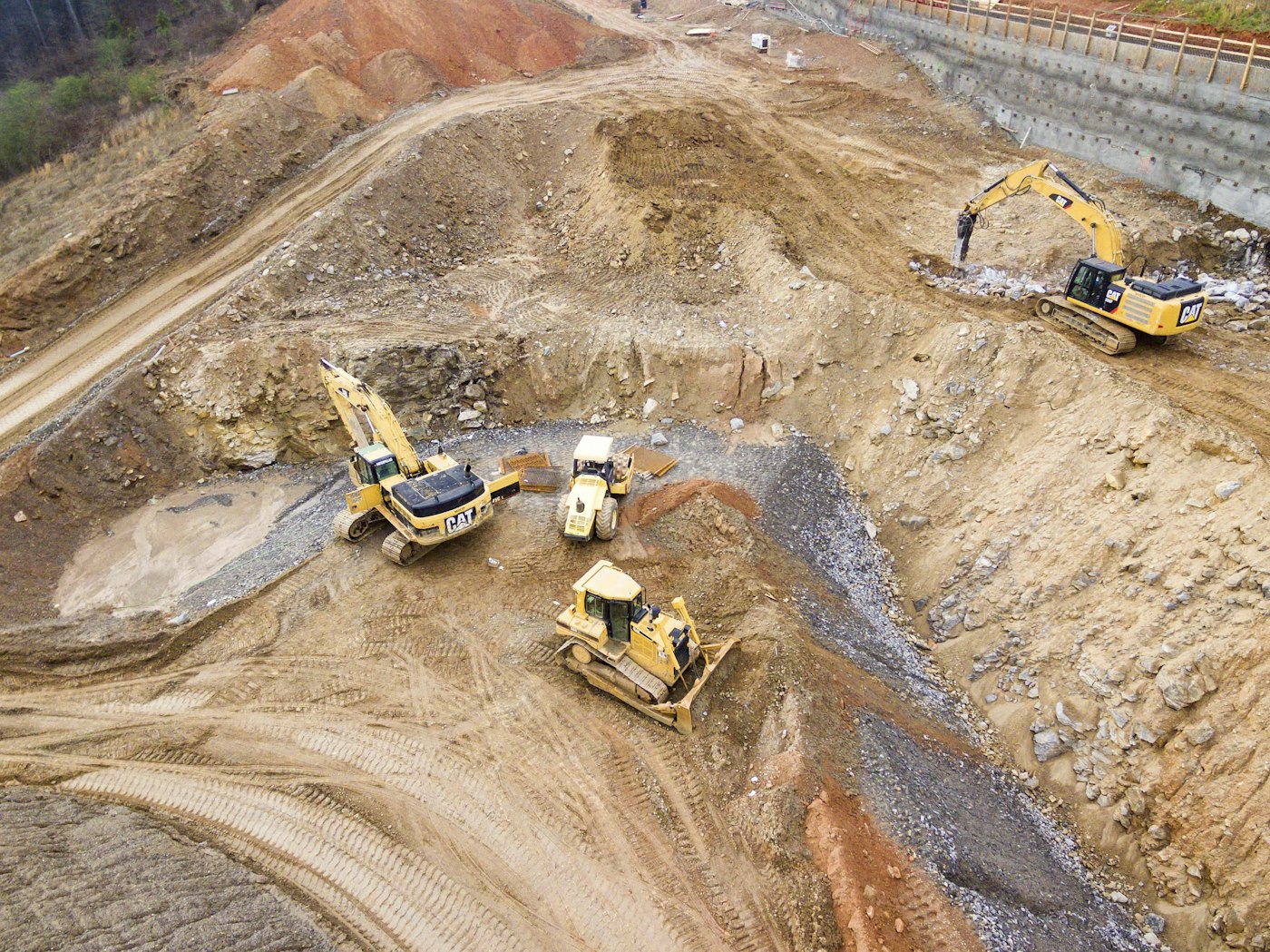 Heavy equipment clearing and grading land at a job site